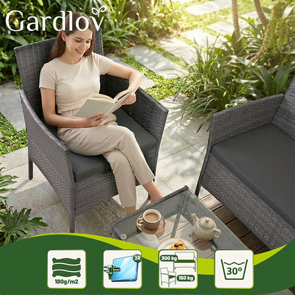 Ensemble de mobilier de jardin en rotin, gris foncé, comprenant un canapé, deux chaises et une table.